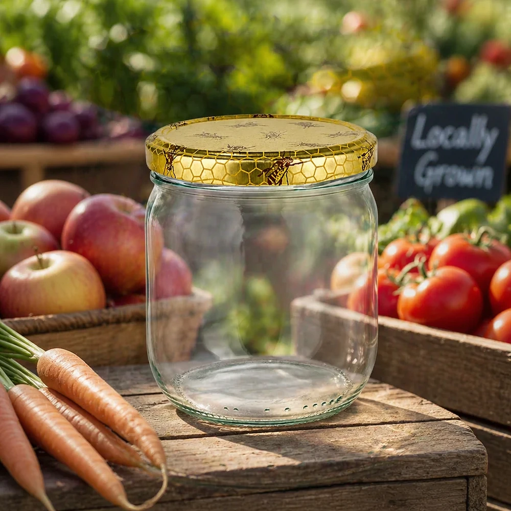 Pot à miel 500 g avec couvercle motif rayon de miel BasicSeal UNiTWIST Pot de miel vide de 500g avec couvercle en nid d'abeille sur une planche en bois entre des légumes frais du marché fermier