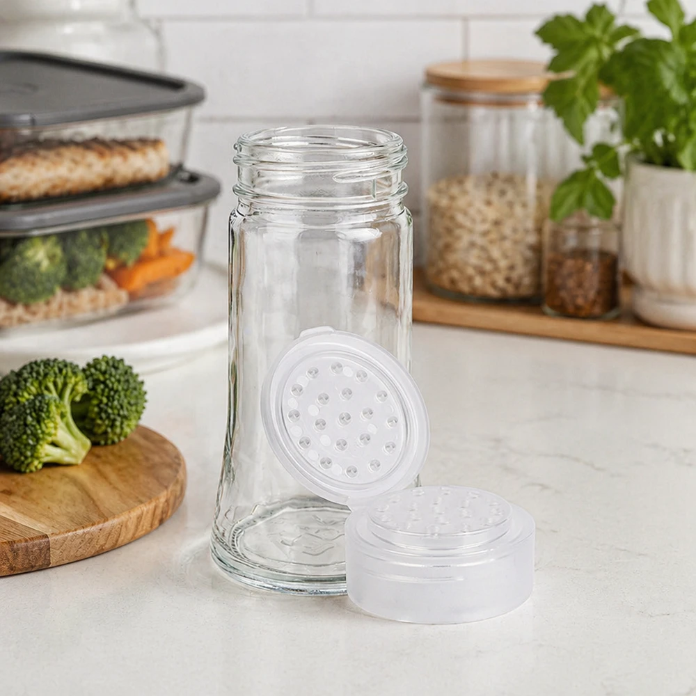 Pot à épices transparent de 95 ml avec saupoudreuse à trous blanche, dans une cuisine moderne avec des légumes frais