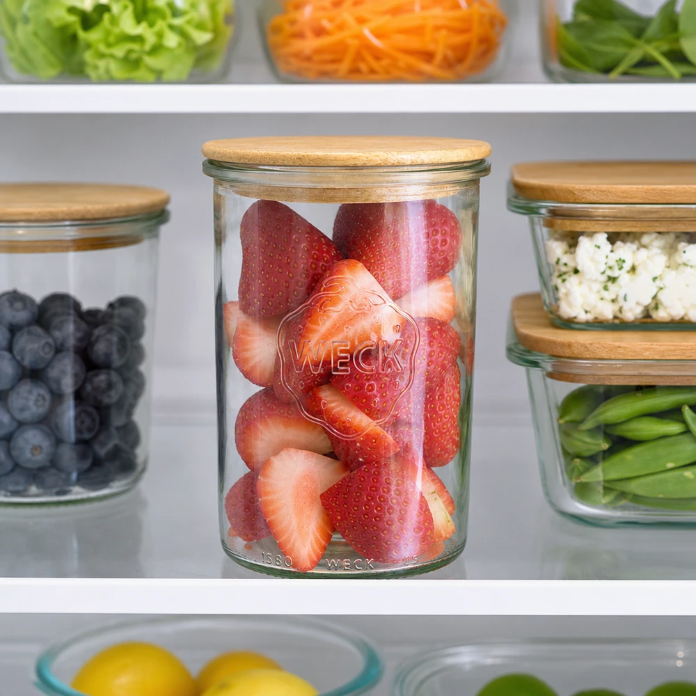 WECK Bocal à provisions 1000ml avec couvercle en bois rempli de fraises dans le réfrigérateur à côté des myrtilles et des légumes