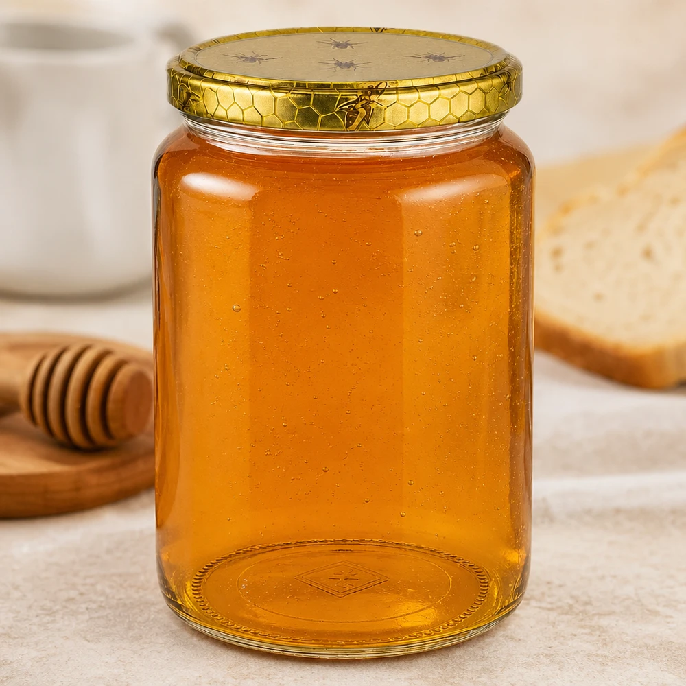 Grand pot de miel de 1 kg sur une planche en bois avec pain et cuillère à miel