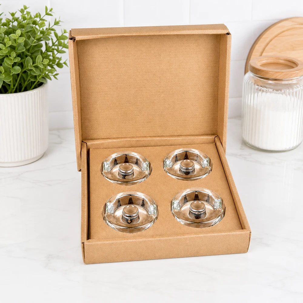 Ensemble de 4 poids en verre Poids en verre de fermentation UNiTWIST, set de 4, ouvert dans une boîte marron, à côté de la plante et du bocal de stockage