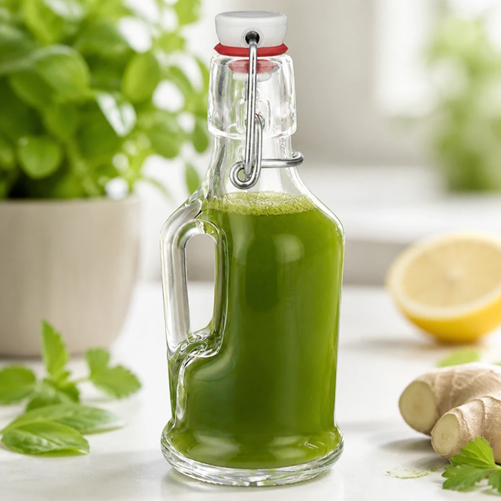 Bouteille en verre 200 ml « Bertha » et bouchon en porcelaine UNiTWIST® Bouteille en verre Bertha 200ml remplie de smoothie vert à côté de gingembre et de citron Scène de cuisine UNiTW Bouchon à étrier