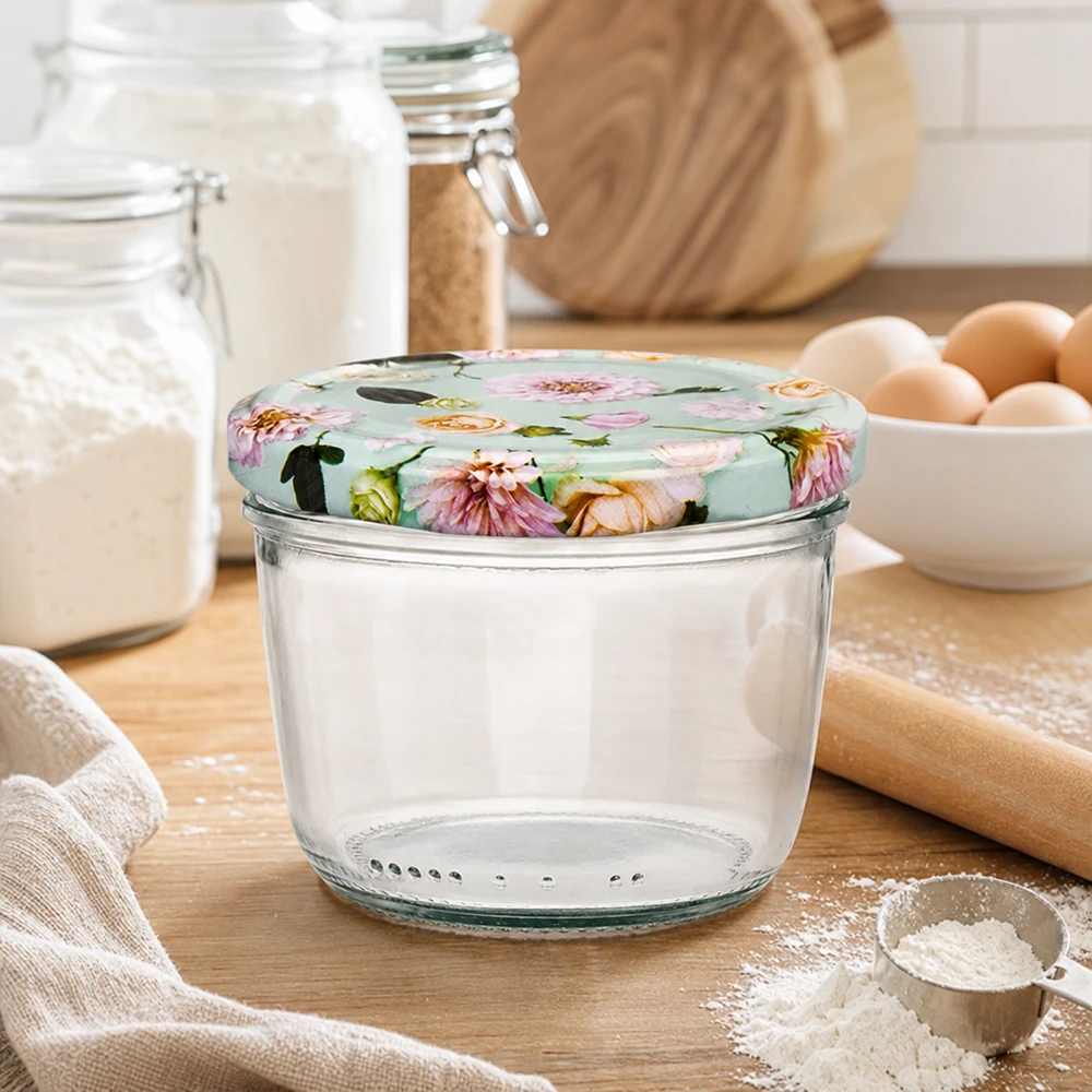 Verres de 230 ml + couvercle BasicSeal fleur menthe UNiTWIST Verre renversé de 230 ml avec couvercle BasicSeal dans la cuisine lors de la cuisson, entouré de farine, d'œufs et d'ustensiles de cuisson