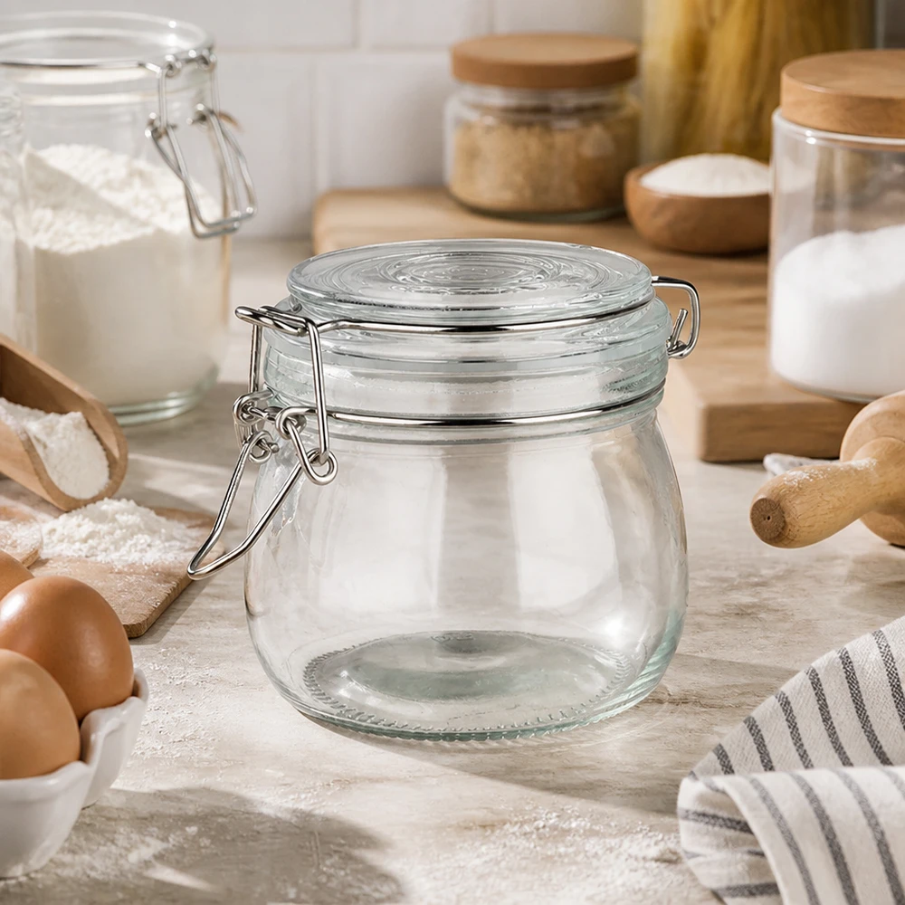 Pot de réserve 500ml type S avec fermeture à étrier UN.. Bocal à provisions vide de 500 ml avec fermeture à étrier dans une cuisine claire, à côté des ingrédients de cuisson et des œufs.