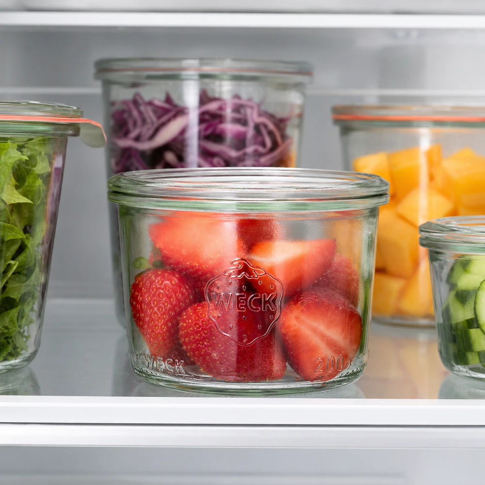WECK Pot renversé 200ml RR80 avec des fraises fraîches dans le réfrigérateur à côté d'autres pots remplis de légumes et de fruits
