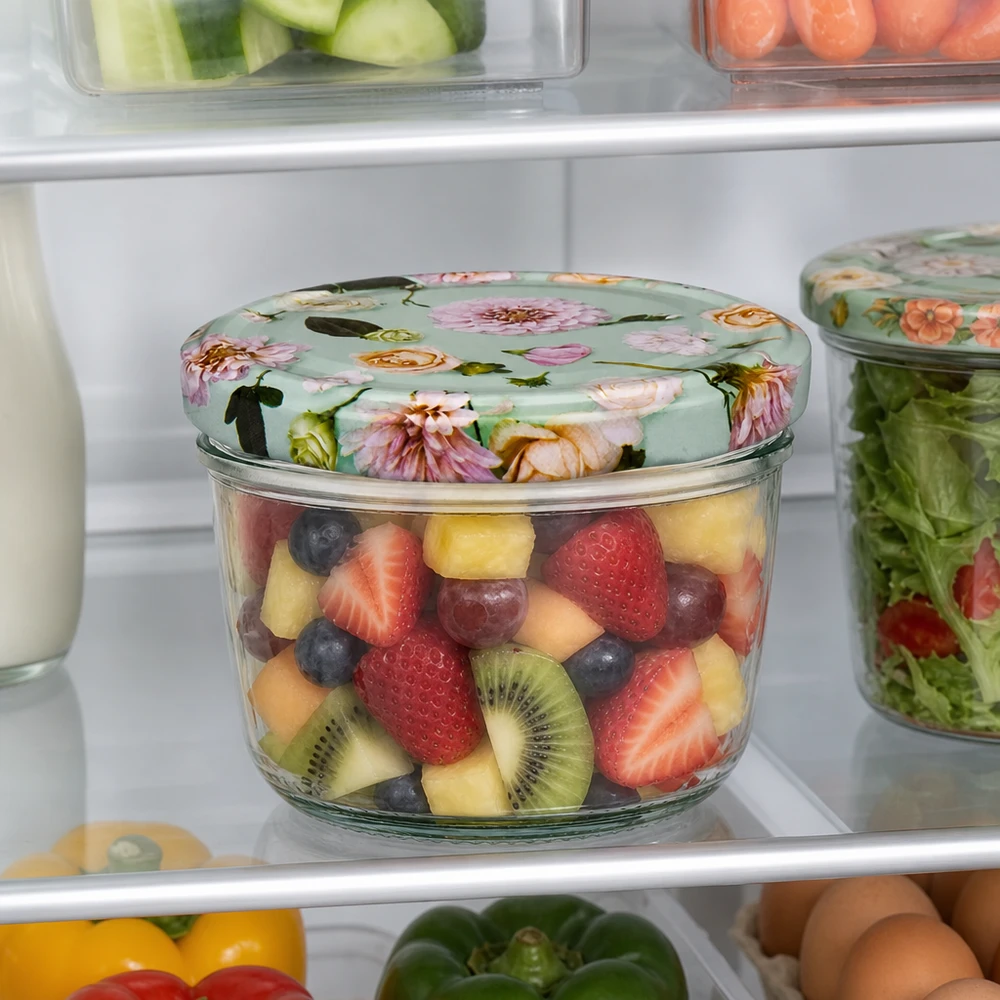 Pot renversé de 230 ml avec couvercle BasicSeal fleur menthe rempli de salade de fruits au réfrigérateur à côté d'autres récipients de stockage