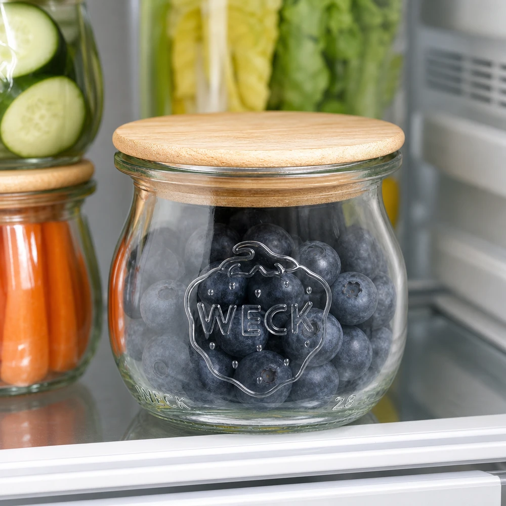 WECK Pot tulipe RR40 75ml avec couvercle en bois rempli de myrtilles dans le réfrigérateur à côté d'autres bocaux à provisions