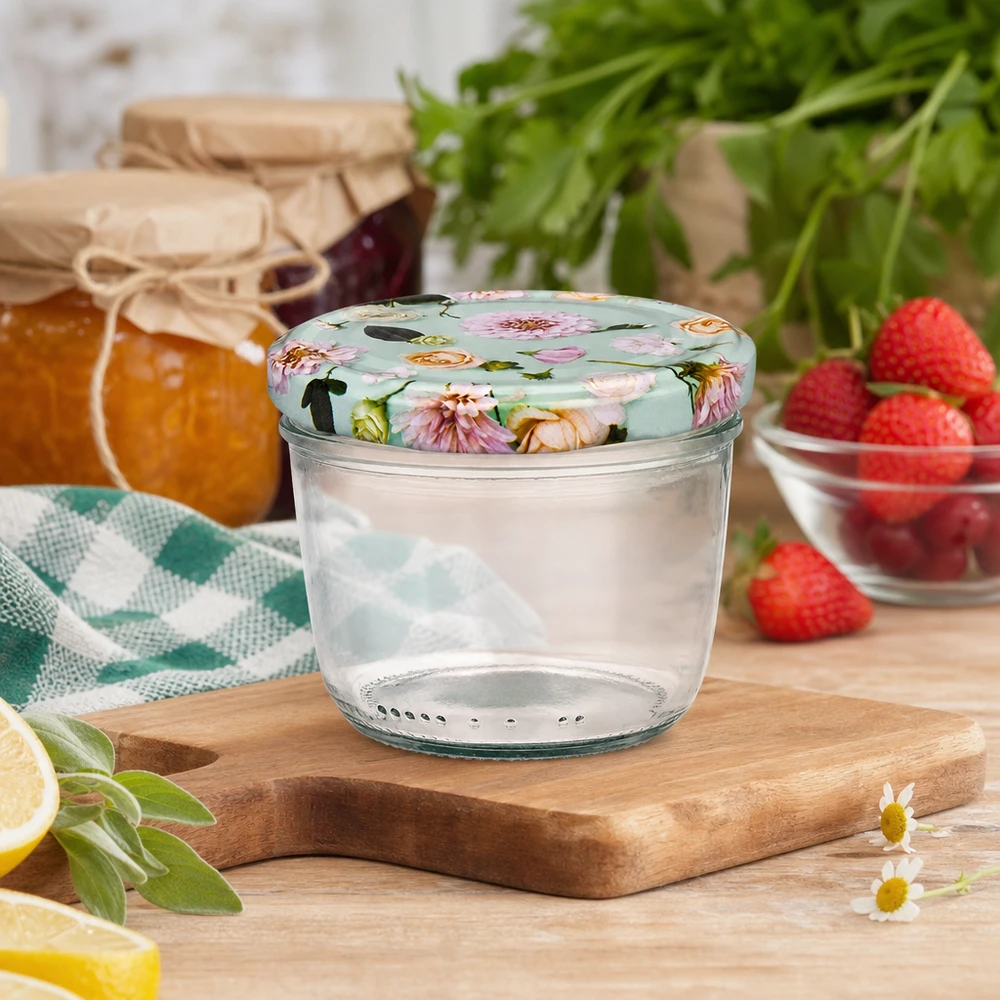 Verres de 230 ml + couvercle BasicSeal fleur menthe UNiTWIST Pot renversé de 230 ml avec couvercle BasicSeal floral sur planche en bois, scène de cuisine avec confiture de fraises et herbes aromatiques